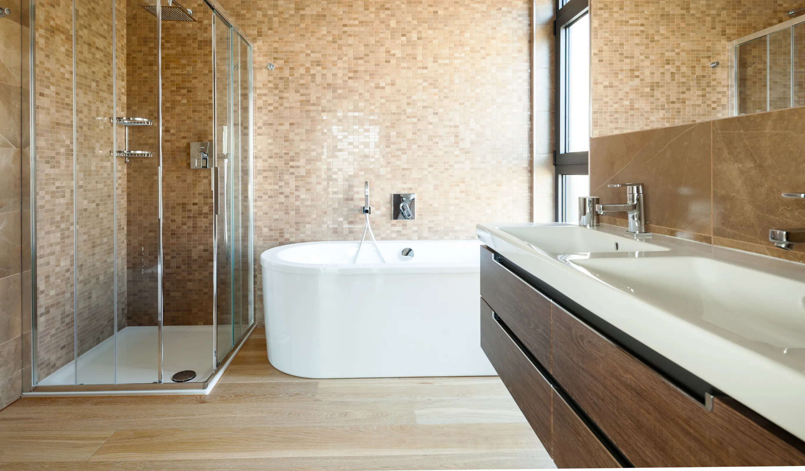 After view of a Los Angeles bathroom remodeling project with walk-in glass shower, freestanding bathtub, double vanity, modern tile walls, upgraded lighting, and spa-style bathroom design